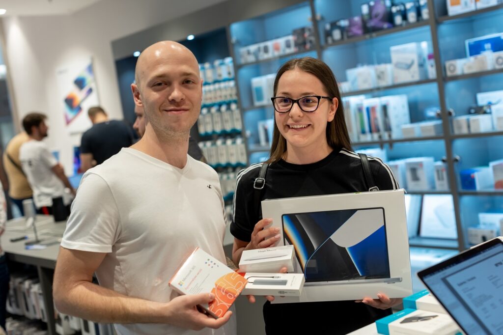 two people are at a retail sales desk in a hi tech store