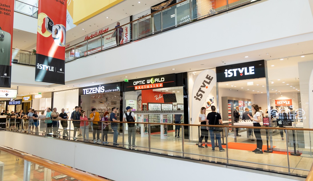 a queue of people in a mall outside a hi tech store