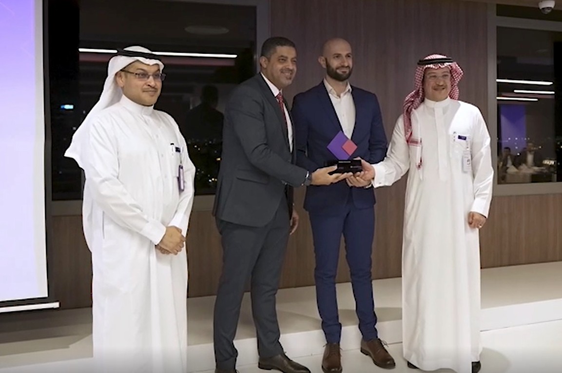 Four men are seen as a trophy is handed over.