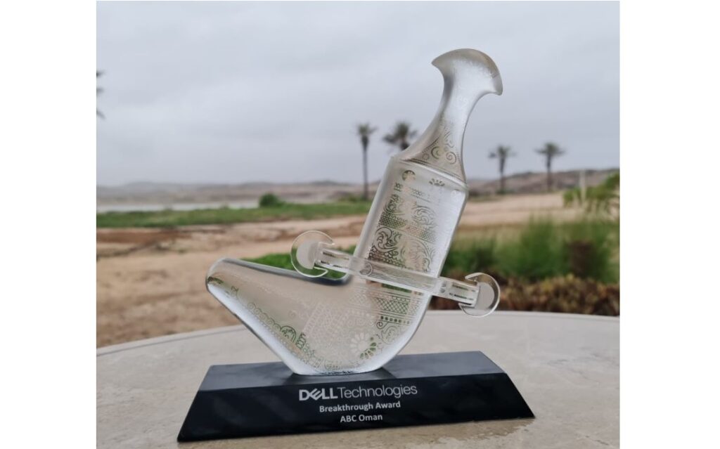 shows a glass trophy set on a plinth outdoors