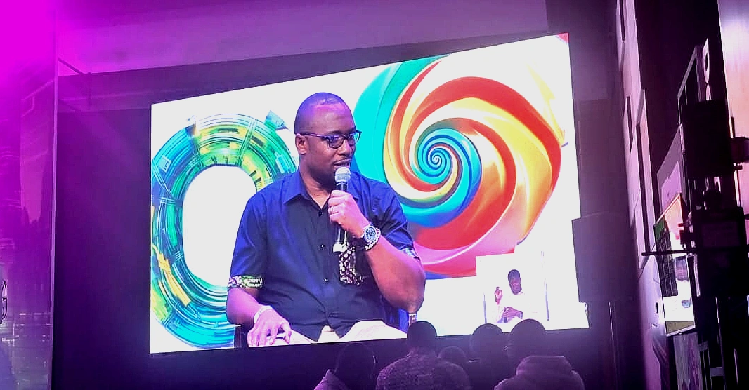a man is seen on a presentation screen talking into a mic