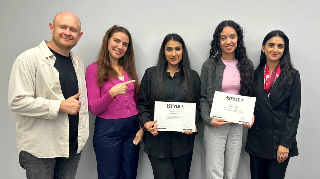 five people in a group photo with two of them holding award certificates