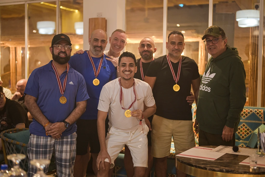 seven men are seen in a group photo with four of them wearing gold medals