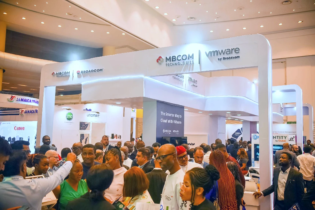 An exhibition stand at a hi tech event in Nigeria. Many people are seen talking at the stand.