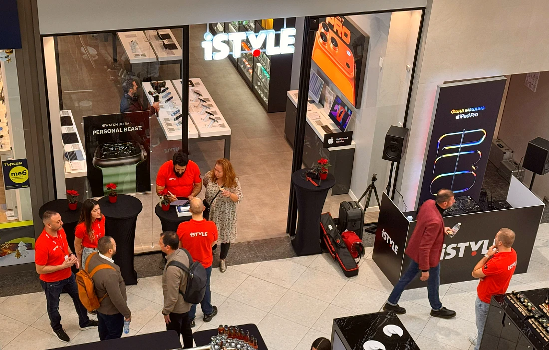 Exterior view from above of a hi tech store. People have gathered outside the store at an opening event