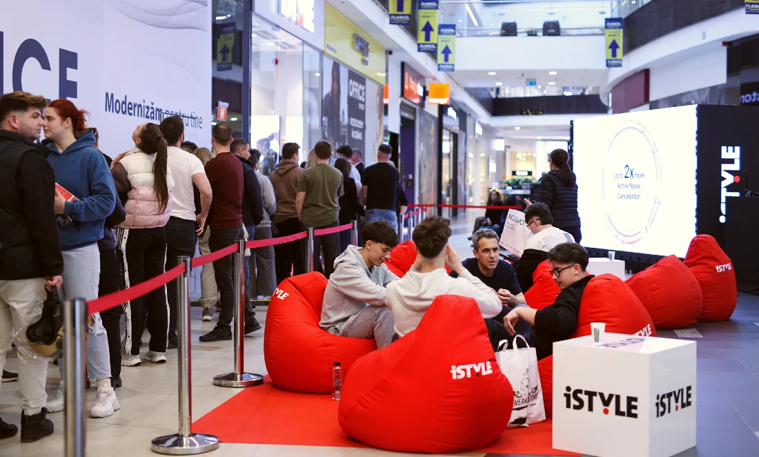 on voit des gens se détendre lors de l'ouverture d'un magasin de haute technologie, assis sur des poufs rouges.